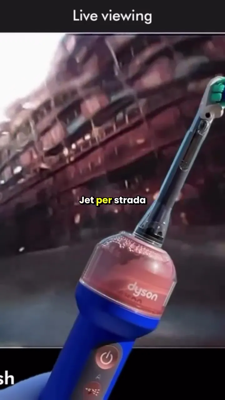 Un creator in strada punta lo spazzolino elettrico Dyson CameraJet come una fotocamera, mentre segue l’inquadratura in diretta sullo schermo dello smartphone