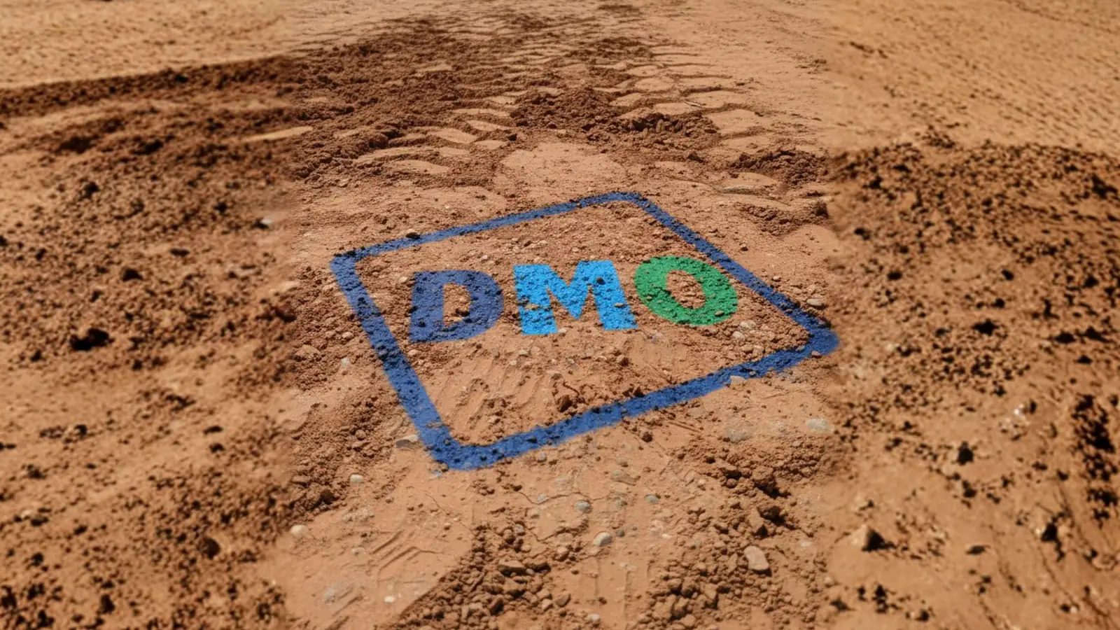 Il logo di DMO S.p.A. disegnato sulla terra di un cantiere: identità di marca costruita da ByMarke